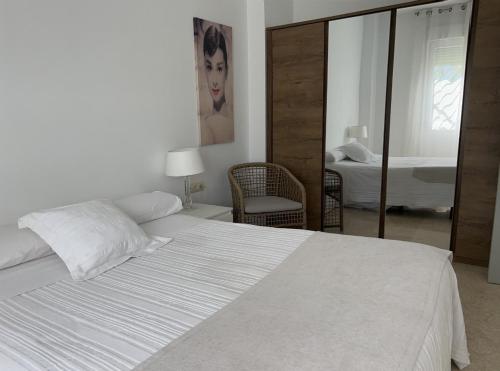 博尔穆霍斯Seville Luxury Apartment Parking Opcional的卧室配有一张带镜子的白色大床