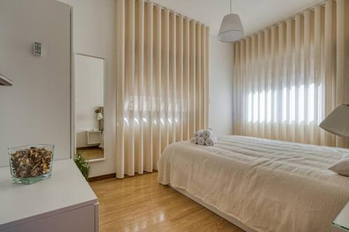 马亚Spacious House in Porto for family and friends的一间卧室设有一张床和一个大窗户