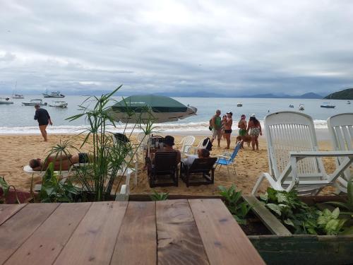 阿拉夏奇巴海滩Espaço Villa Ará的一群人坐在沙滩上的椅子上