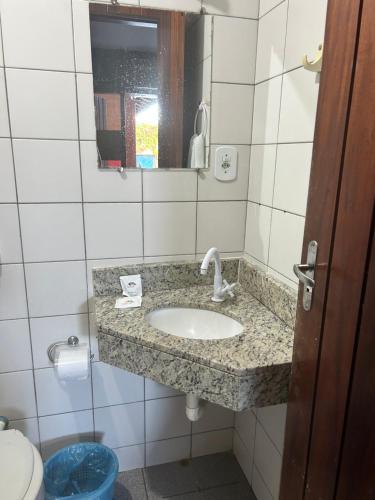 康塞桑达巴拉太阳酒店的一间带水槽、镜子和卫生间的浴室