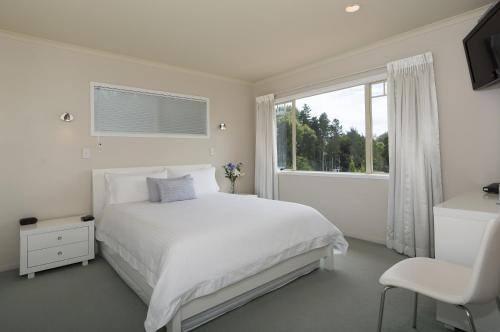 陶朗加海景别墅住宿加早餐酒店的白色的卧室设有白色的床和窗户。