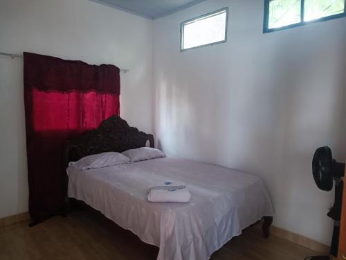 莱蒂西亚Apartamento Profe Rios的卧室配有白色的床和红色窗帘