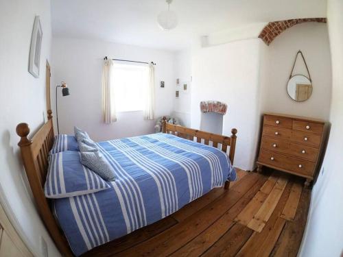 BigburyCosy Beachside Cottage的一间卧室配有一张床,铺有木地板