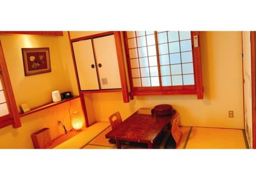 奈良Nara Ryokan - Vacation STAY 49547v的一间带桌子和窗户的用餐室