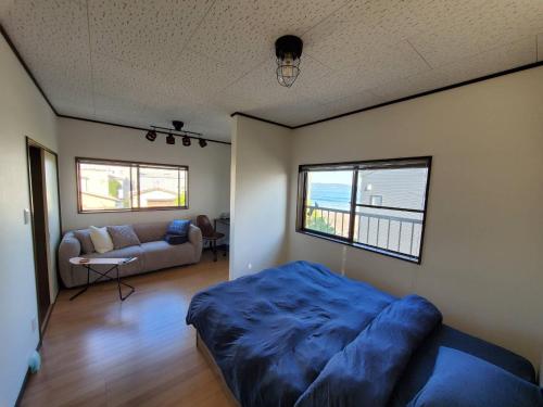 鸭川市Ocean View Kamogawa - Vacation STAY 61073v的一间卧室配有一张床,客厅配有沙发