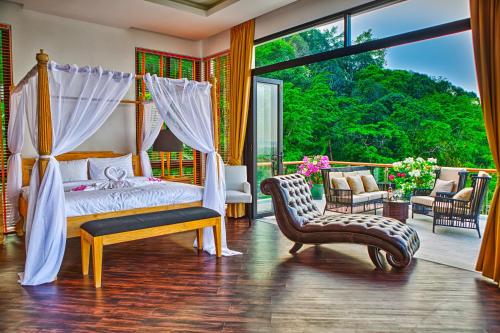 邦涛海滩Fully Serviced Grand Villa Luxury Time Phuket的一间卧室配有一张天蓬床和一把椅子