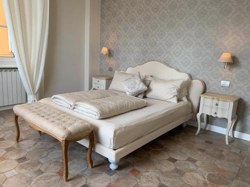 坎诺比奥Spiaggia Amore - Appartamenti Vacanza Vista Lago的卧室配有白色的床和凳子