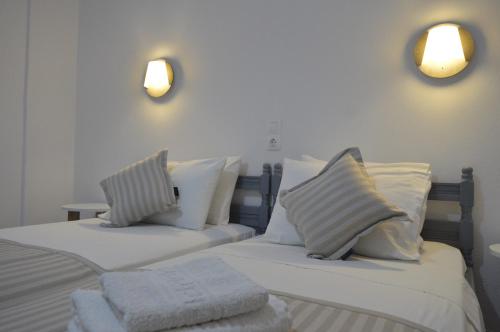 斯基亚索斯镇Pansion L'isola的一间卧室配有两张带白色床单和枕头的床。