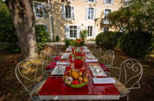 Lagraulet-du-GersLe Castel Pierre - Maison privée 4 étoiles - 18 personnes的一张长红的桌子,上面放着一碗水果