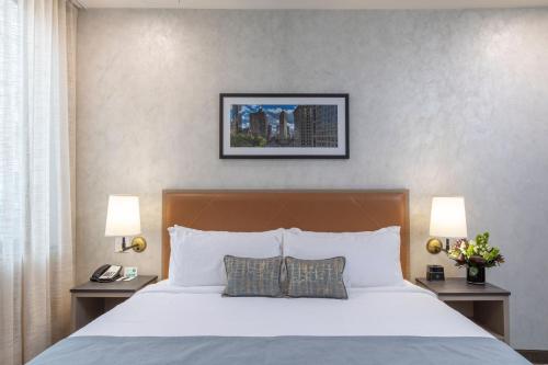 纽约百老汇广场酒店的一间卧室配有一张带2个床头柜和2盏灯的床。