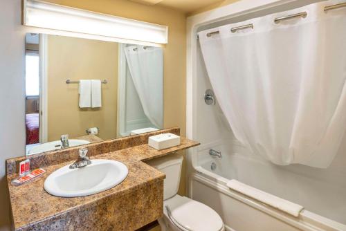 米拉米契Econo Lodge Miramichi的一间带水槽、卫生间和镜子的浴室