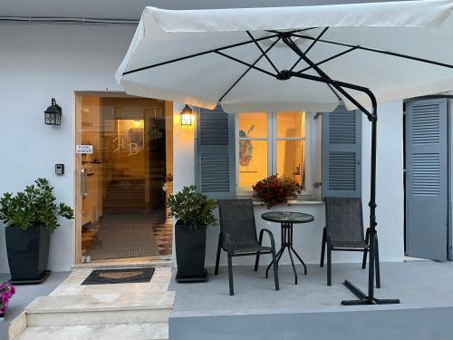 贝尼蔡斯HB Hotel Benitsa的庭院配有桌椅和遮阳伞。