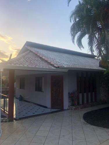 伊瓜苏Casa em Foz do Iguaçu的棕榈树白色的小房子