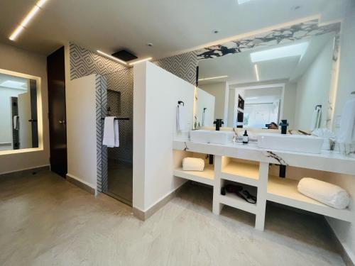 圣何塞德尔卡沃Marisol Hotel Boutique的一间带两个盥洗盆和大镜子的浴室