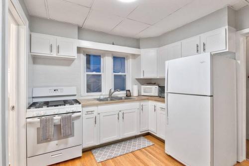 锡拉丘兹Charming Cuse home close to downtown & university的厨房配有白色橱柜和白色冰箱。