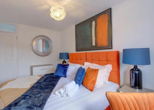 RobyFree Parking Large House Huyton Golf Club M57的一间卧室配有一张带橙色床头板的床