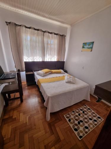 沙佩科CASA DO PINHEIRO 2的一间卧室配有一张床、一张书桌和一个窗户。