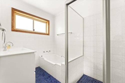 纳鲁马3 Bay Lane的白色的浴室设有浴缸和水槽。