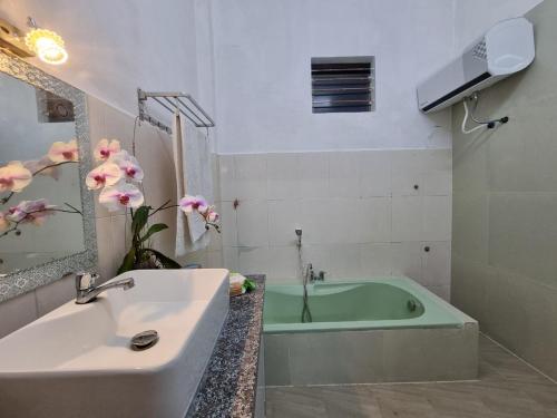 Ðông Mỹ (2)Katie's homestay的带浴缸和盥洗盆的浴室