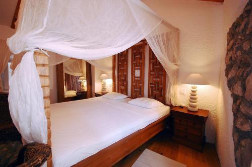 克尔克普拉卡精品酒店的卧室配有带白色床单的天蓬床