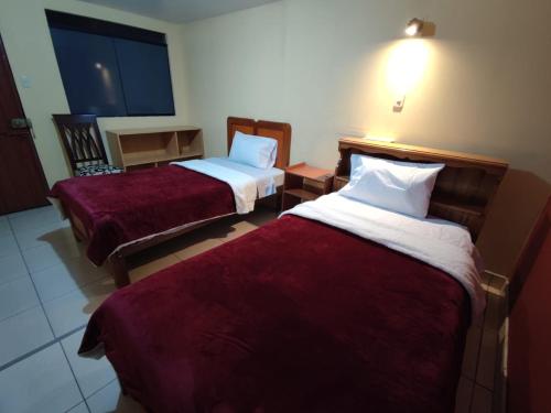 阿雷基帕Casa particular的酒店客房,配有两张带红色床单的床