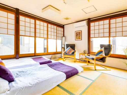 奈良Nara Guesthouse 3F的一间卧室设有一张大床、椅子和窗户。