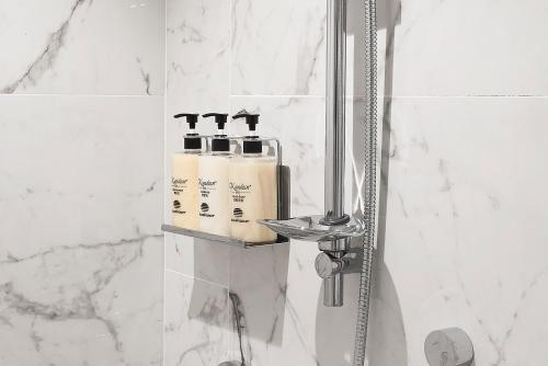 台北ILLUME 茹曦酒店的浴室设有淋浴和2瓶洗发水