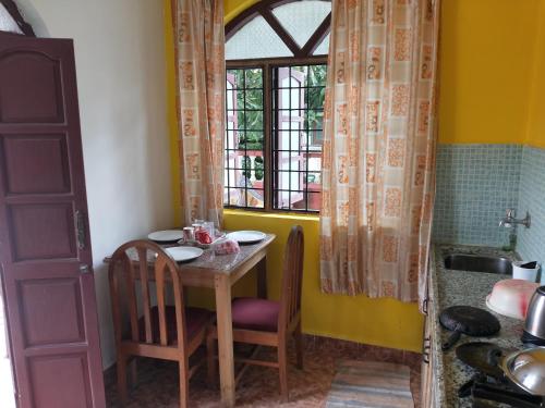 AguadaAlexmarie Guest house 5 min to candolim Beach的一个带桌子和窗户的小厨房