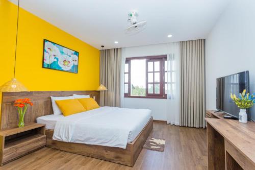 顺化SOLEIL BOUTIQUE的一间卧室设有一张床和黄色的墙壁