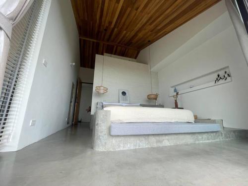 西塔努Villa Nour - 3 BR sea view pool villa in Srithanu的一间卧室设有一张带木制天花板的大床