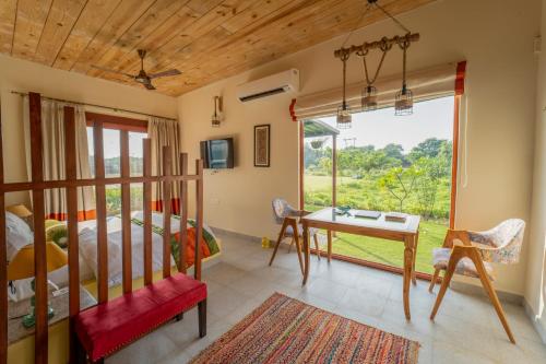 阿格拉Tree of Life Ecotainers Agra的一间卧室配有一张床、一张书桌和一个窗户。