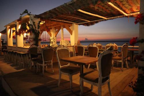 拉斯阿尔卡麦Banan Beach的一间设有桌椅的海洋餐厅