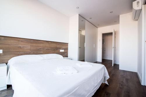 雷乌斯3-2 Apartamento de diseño en el centro de Reus的卧室配有白色的床和木制床头板