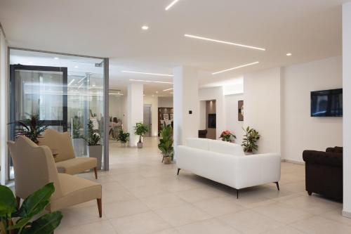 阿巴迪亚圣萨尔瓦托雷Amiata Suite的医院的大堂,配有白色的沙发和椅子