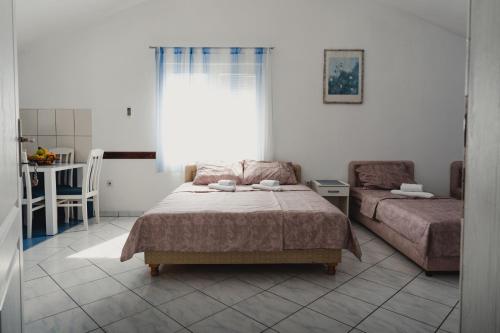 蒂瓦特Apartments Djukic的一间卧室设有两张床、一张桌子和一个窗口