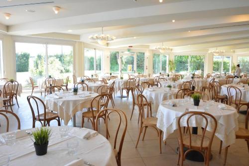 米兰马瑞提那Hotel Bellevue Beach - sul mare的宴会厅配有白色的桌椅