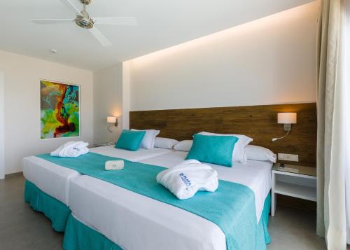 滨海罗克塔斯Playalinda的两张位于酒店客房的床,配有毛巾