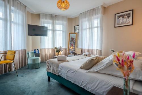 比亚里茨Ama Hôtel的一间带大床和电视的卧室