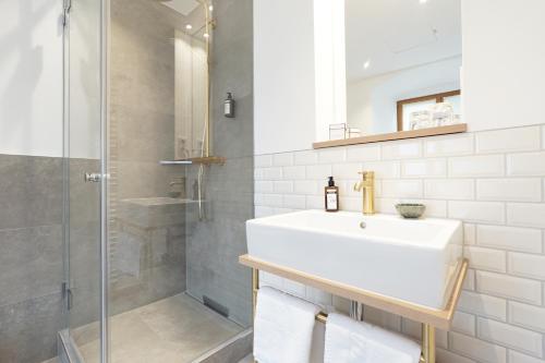 拜尔恩格里斯Schattenhofer Braugasthof的白色的浴室设有水槽和淋浴。