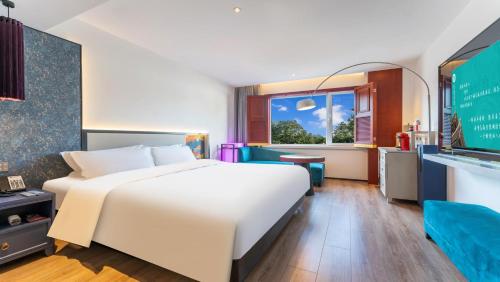 北京后海里院酒店的卧室设有一张白色大床和一扇窗户。
