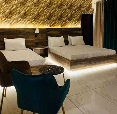 卡拉奇TULIP HOTELS AND APPARTMENTS的一间卧室配有两张床和一张蓝色椅子
