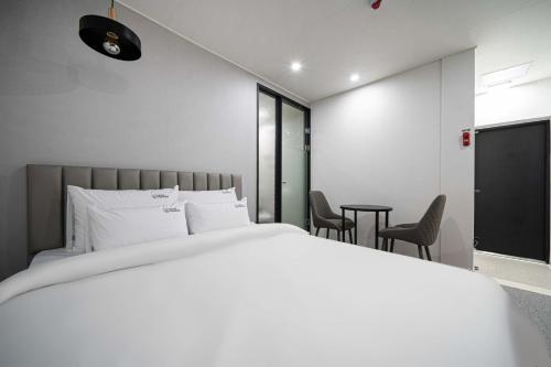 昌原市Hotel Haeseong的卧室配有一张床和一张桌子及椅子