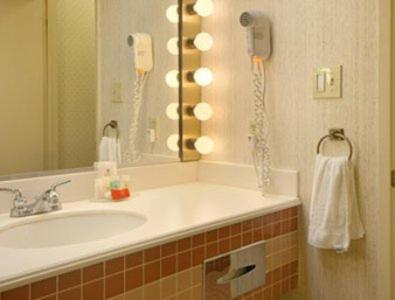 默塞德默塞德套房酒店的一间带水槽的浴室和墙上的一部电话