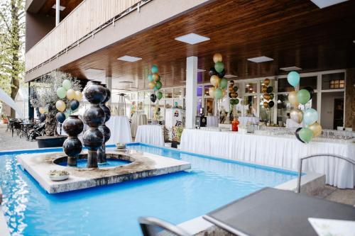 布尔诺Hotel Fontána的一座建筑中间的游泳池,有一个喷泉