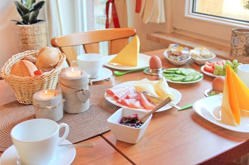 吕本瑙Pension An der Kamske, DZ 3的餐桌,带食物,杯子和盘子