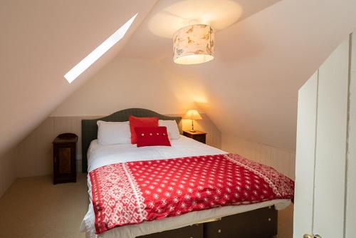 The Bothy, Gallin, Glenlyon, Perthshire的阁楼上的卧室配有红色和白色的床