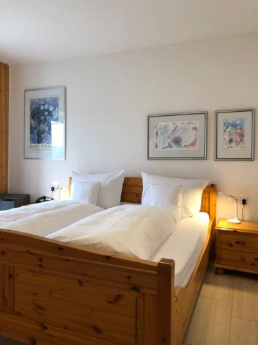 博德曼路德维希港Hotel Sommerhaus Garni am See的一间卧室配有一张大木床和白色床单