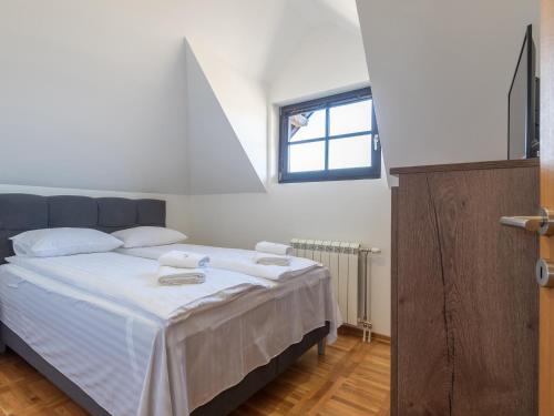 兹拉蒂博尔Velika Recepcija 10的一间卧室配有一张带白色床单的床和一扇窗户。