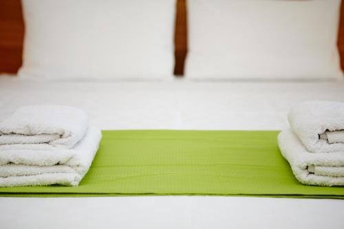 Vokaria阿默蓝多斯海景公寓酒店的浴室内绿色托盘上的两条毛巾