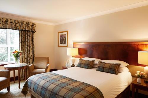 格兰奇茅斯农庄庄园酒店的配有一张床和一把椅子的酒店客房